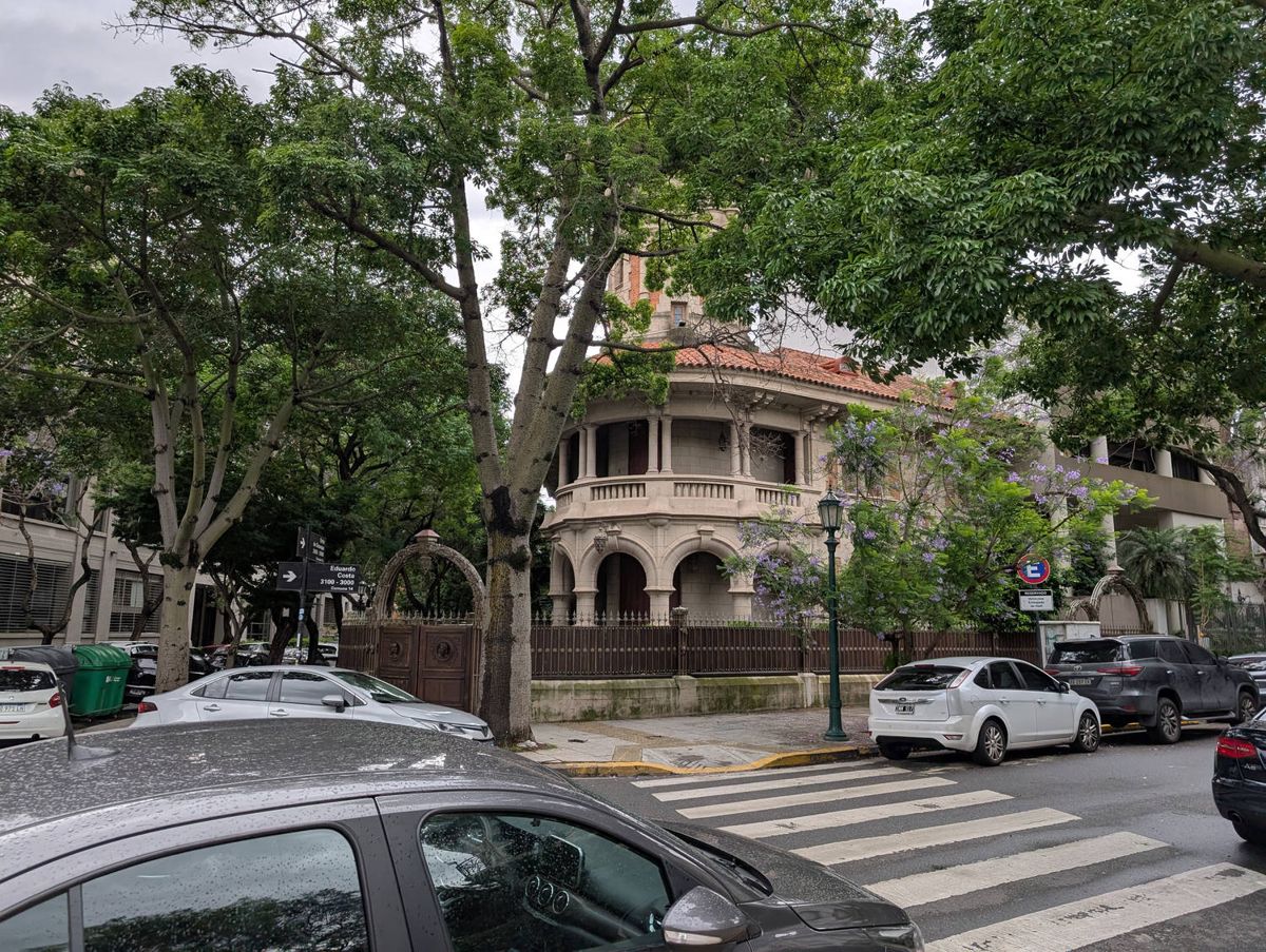 An old house on a corner under the trees