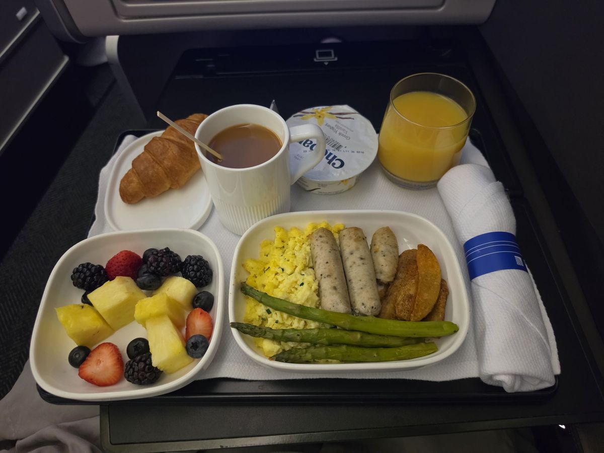 Breakfast before Madrid: eggs, sausage, fruit and a croissant