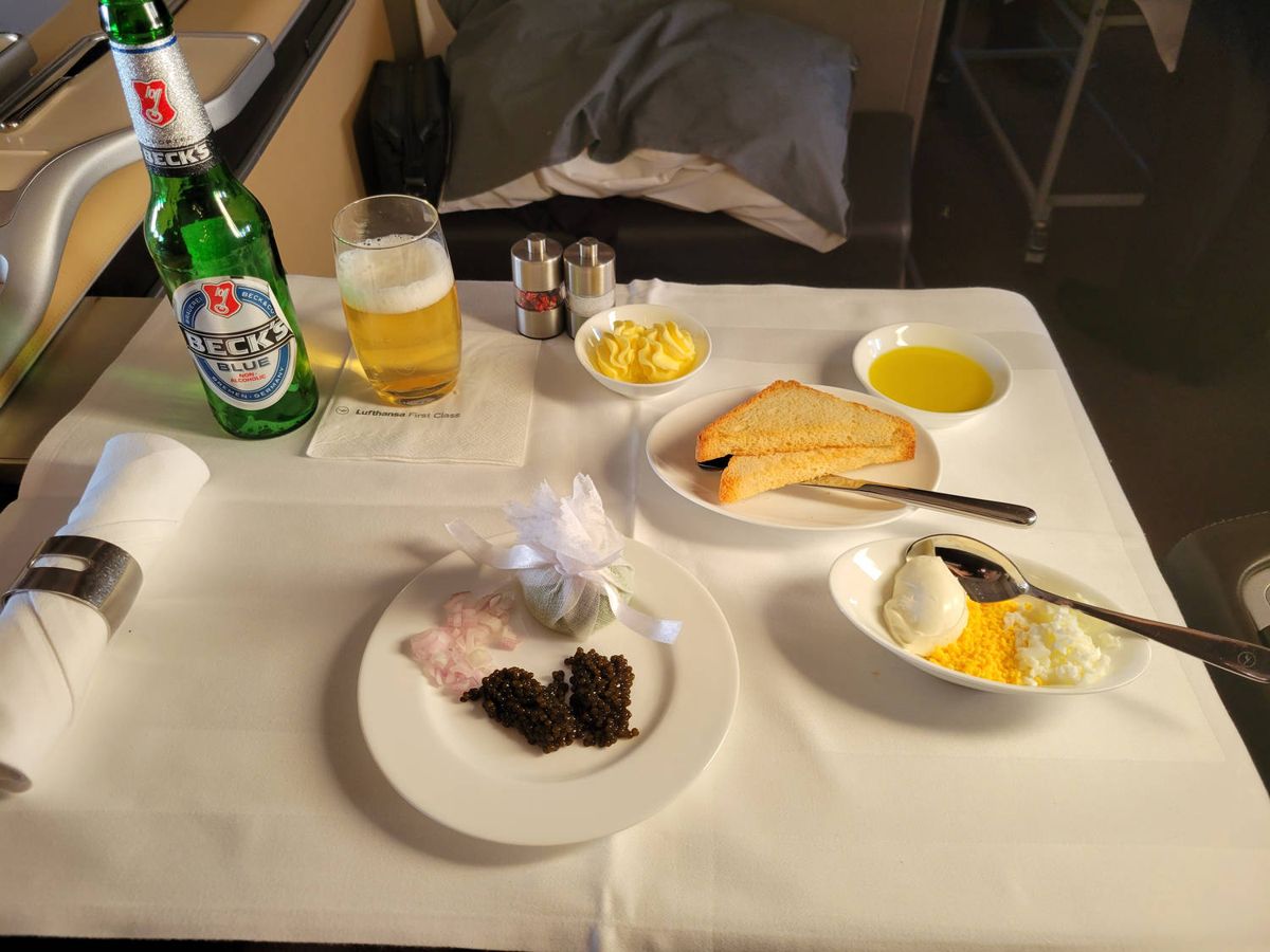 Caviar with toast, onion and egg, a Beck’s Blue beside it