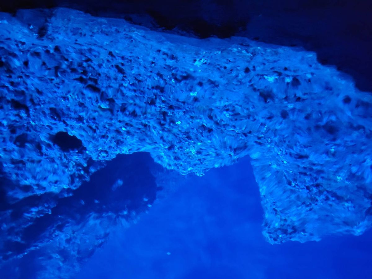 The cave wall over the glowing water
