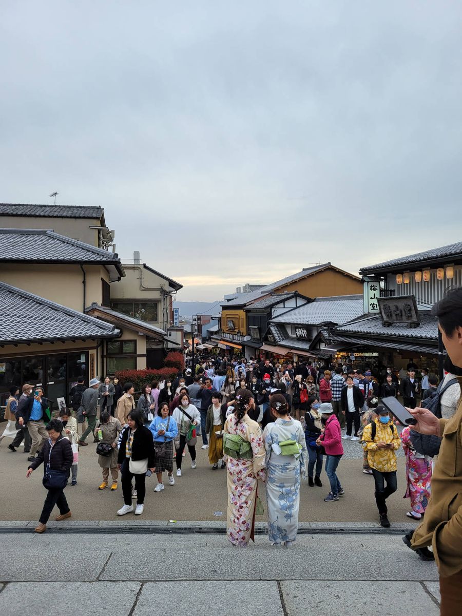 A packed street of shops, people in kimono
