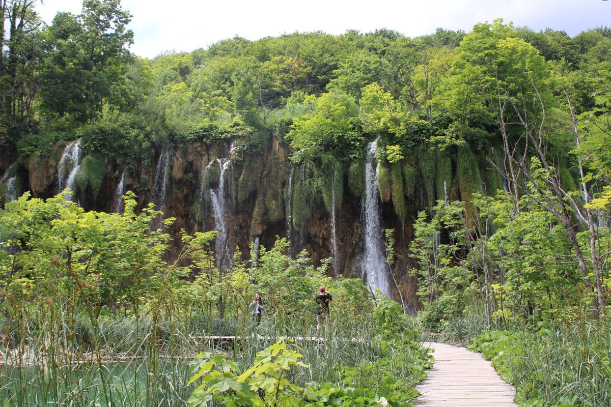 A boardwalk toward a wall of falls
