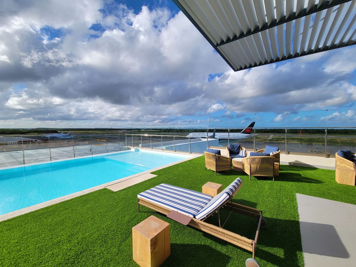 The pool and loungers with an Air Canada 787 behind