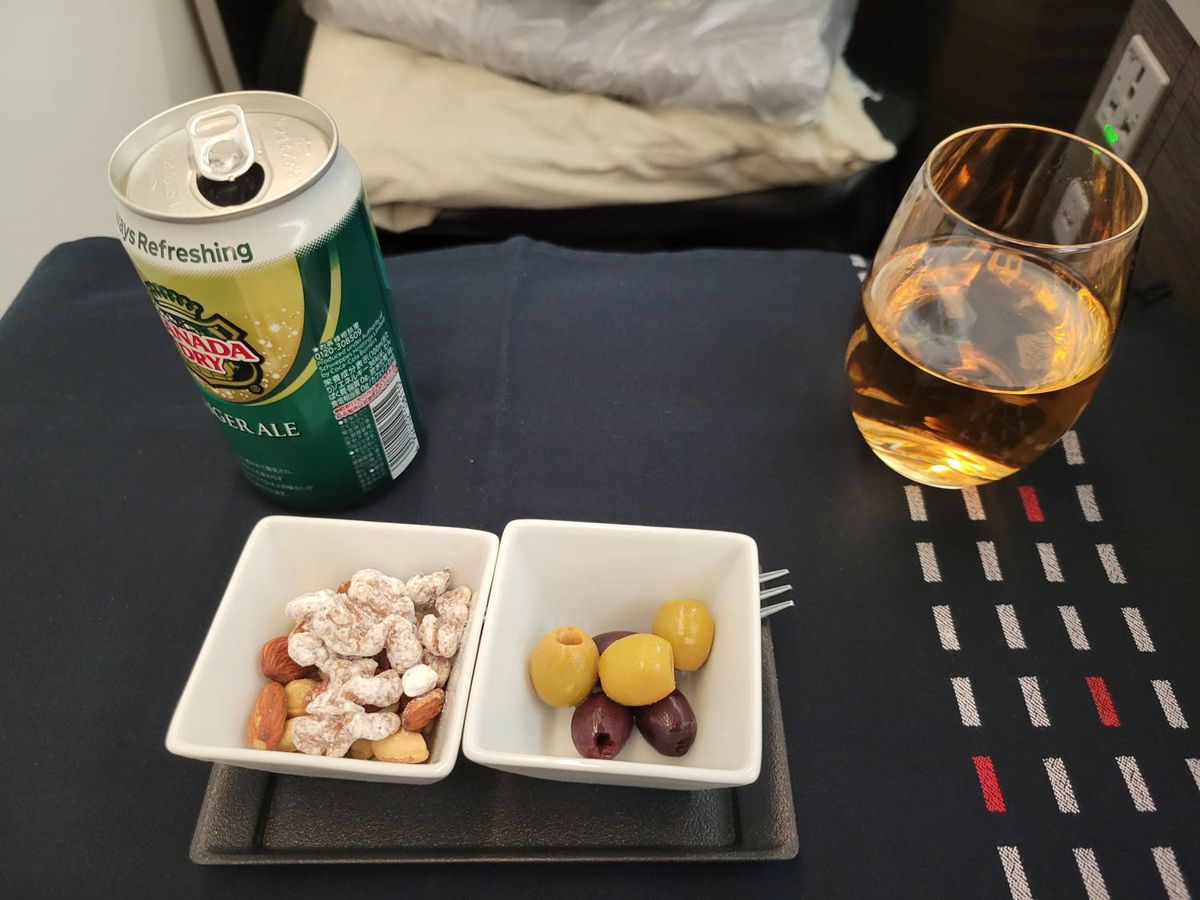 A can of Canada Dry ginger ale with nuts and olives