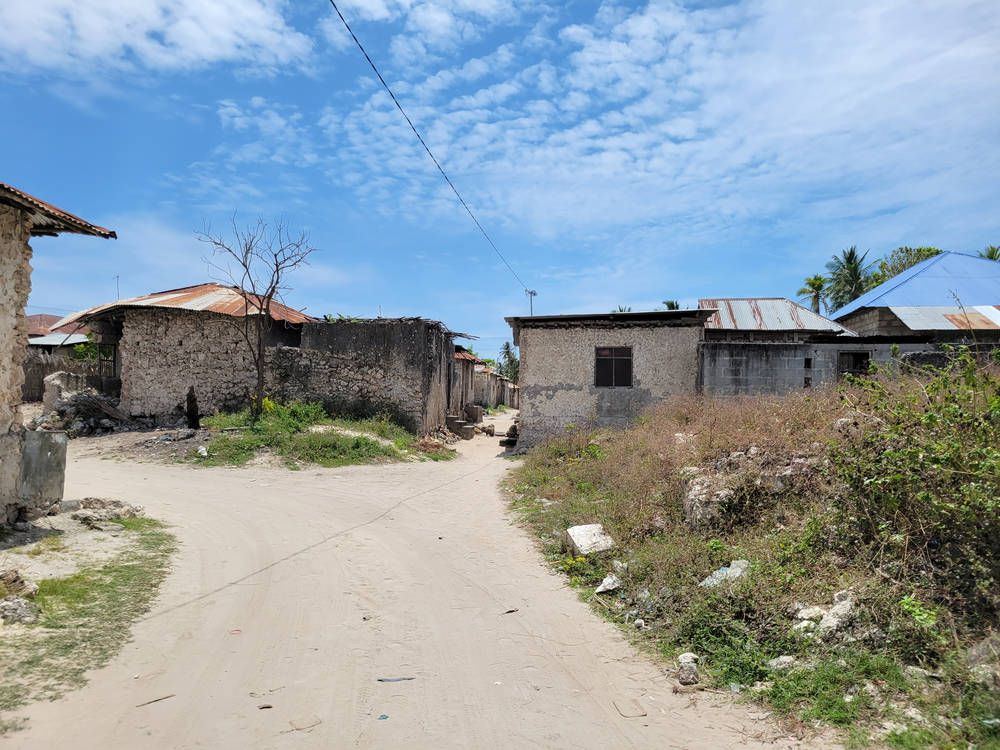A sandy road between stone houses