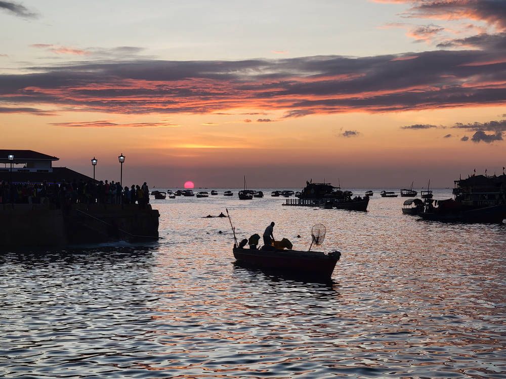 A fishing boat in front of the sunset